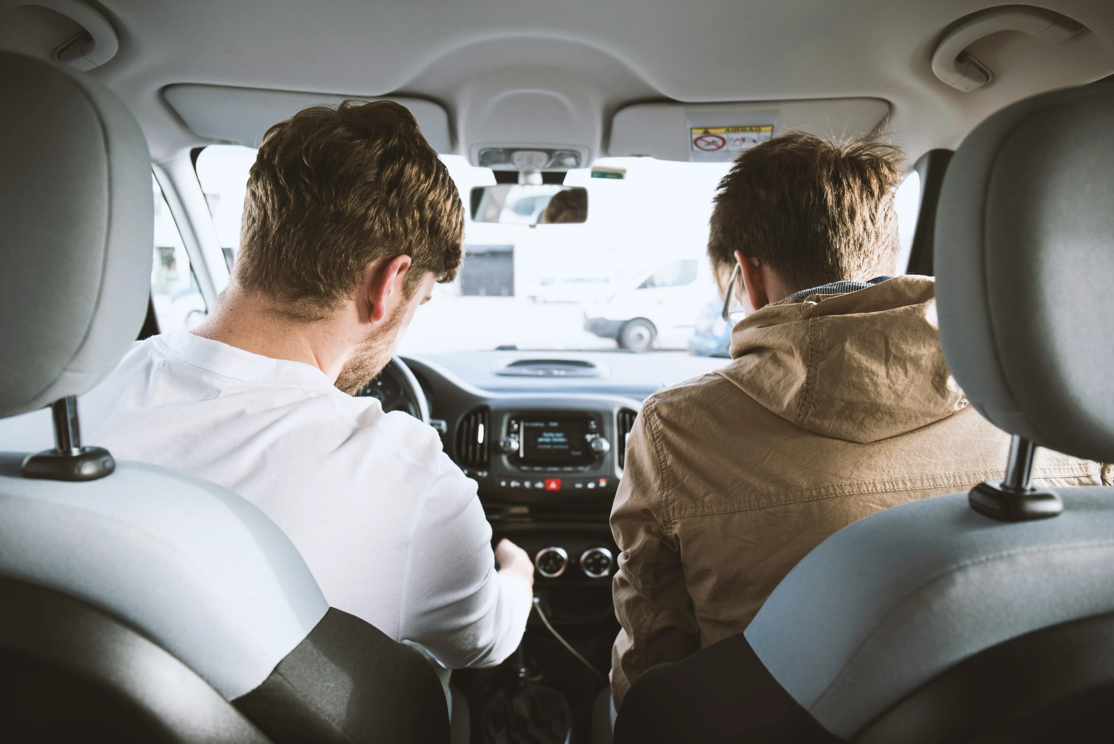 Rijinstructeur en leerling-bestuurder samen in de auto tijdens een rijles